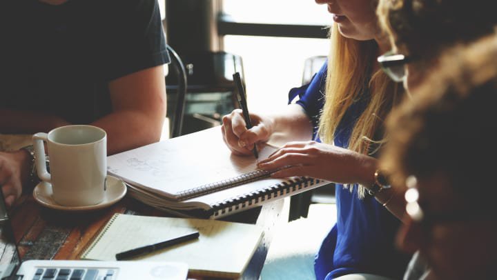 person with long hair taking notes